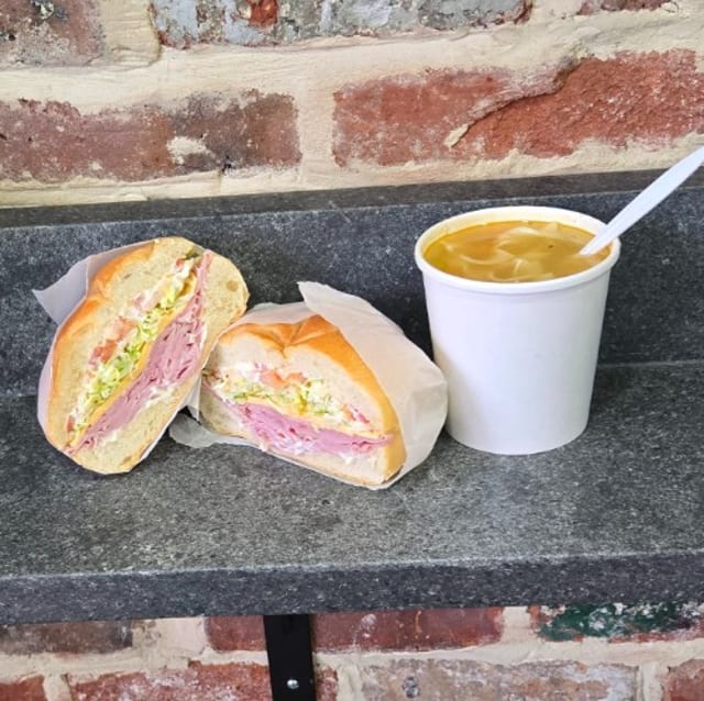 Boars Head Ham, Melted Mozzarella Cheese, Lettuce, Tomato, Oil, Vinegar, and Mayo, on a Roll, with a Small Green Split Pea Soup.
